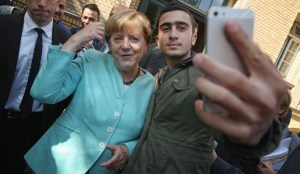 Berlino, selfie dei migranti con la Merkel
